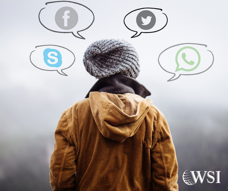 Person standing in a brown coat and hat. Icons of social media platforms around them in speech bubbles.