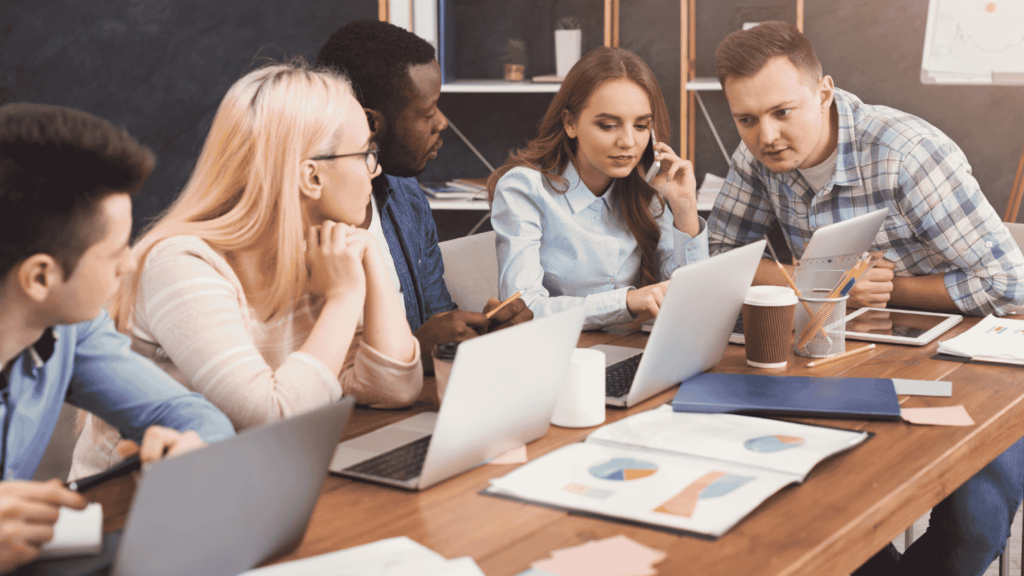 A team of digital marketers sit around a table during a conference call with a client.