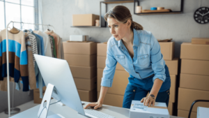 A small business owner looks at their computer to confirm a shipping label.