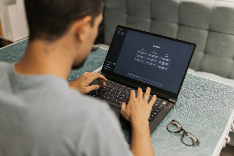 Blog A man searches on a black laptop using the AI search software, ChatGPT.